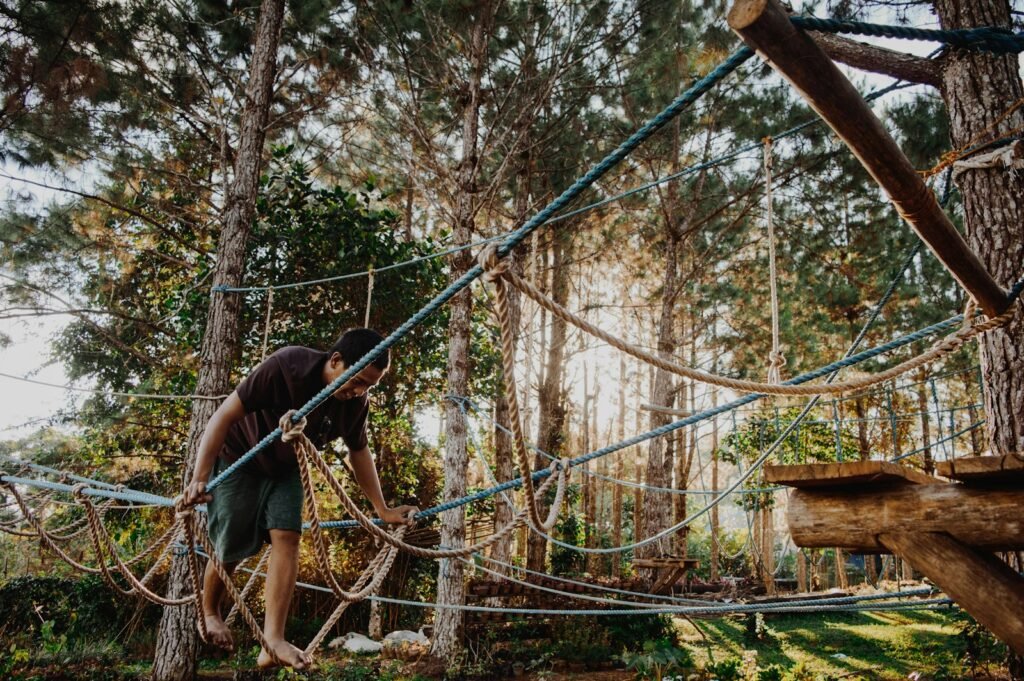 photo of man walking on rope tree, 